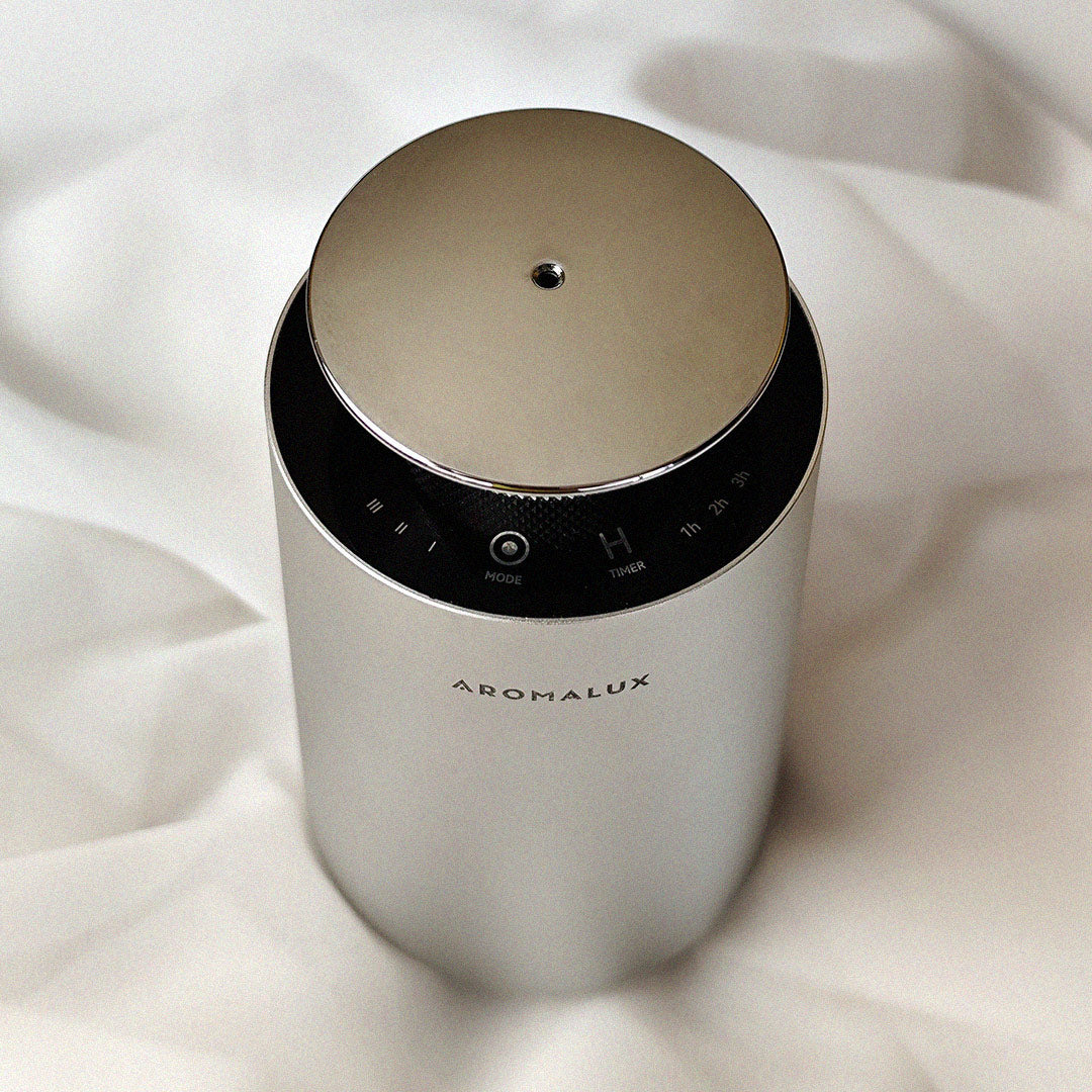 Aromalux Aeolus diffuser on a white fabric background